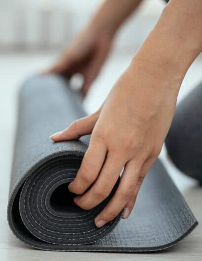 Eine Frau rollt ihre Yoga Matte aus