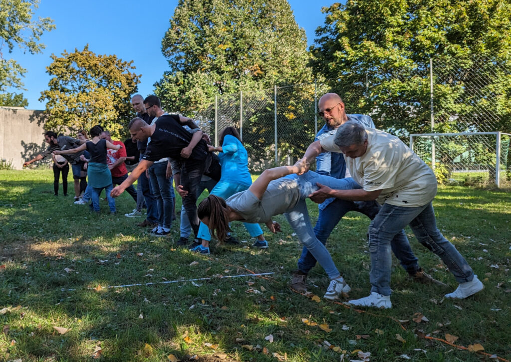 Teilnehmer versuchen in Kleingruppen eine Gummiente möglichst weit von der Startlinie abzulegen.